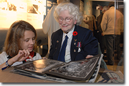 Joan Voller, SWW WREN, showing photos of her experiences, Remembrance Day 2006.
© Canadian War Museum, photo Mark Holleron, CWM2012-0010-0084-Dm
