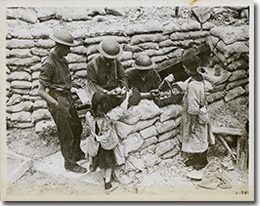 Canadian soldiers buying oranges and chewing gum from two young French girls, July 1917.
George Metcalf Archival Collection
© Canadian War Museum
