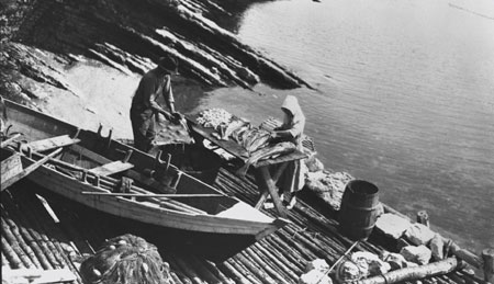 Mr. and Mrs. Roberts cutting up cod on the beach, near Cap des Rosiers (Gaspsie), Qubec, 1922., © CMC/MCC, Marius Barbeau, 57353