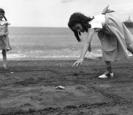 Yvette Larive, 10 ans, jouant  la marelle avec une toile de mer sur la plage de Grande Valle, Gaspsie, Qubec, 1958., © MCC/CMC, Carmen Roy, J15080
