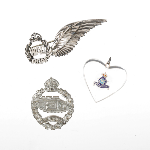 A group of badges with wings and hearts on a white background, showcased at the Canadian War Museum in Ottawa.