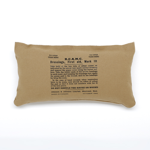 A tan pillow with a message on it, available at the Canadian War Museum.