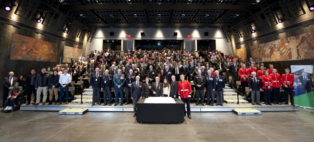 A crowd of veterans stand at the Canadian War Museum.