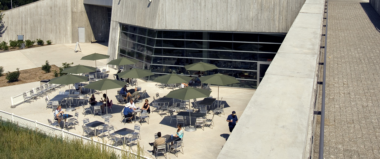 A group of people sitting at tables outside of the Canadian War Museum in Ottawa.