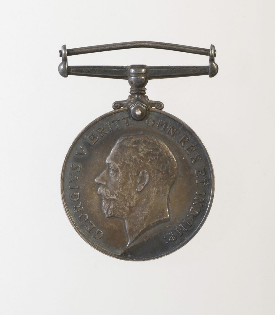 A bronze circular medal engraved with the profile of Britain’s King George V.