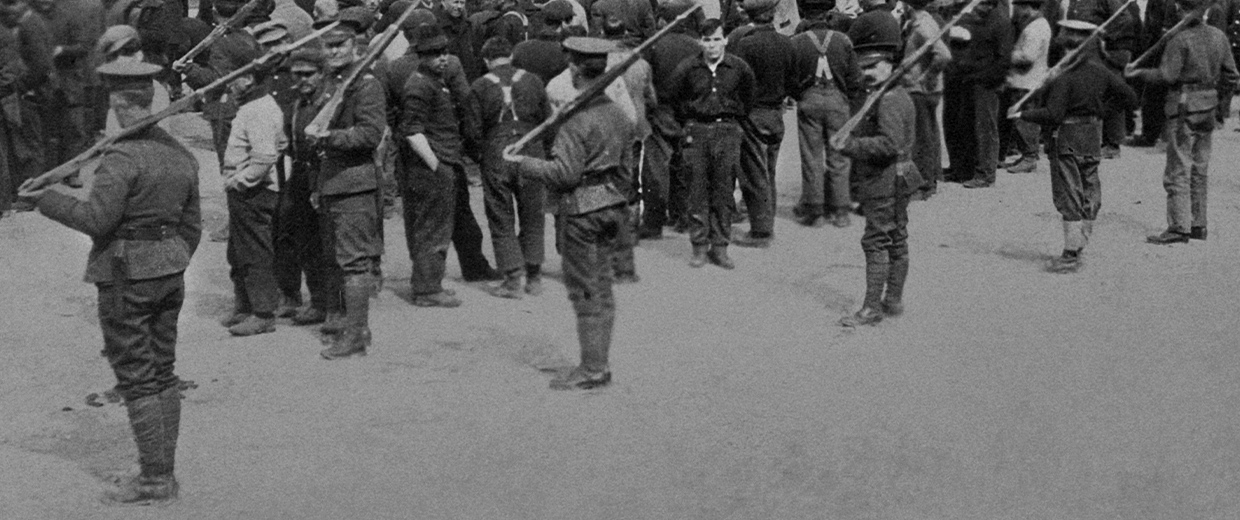 A group of men standing in a line with rifles at the Canadian War Museum, in Ottawa.