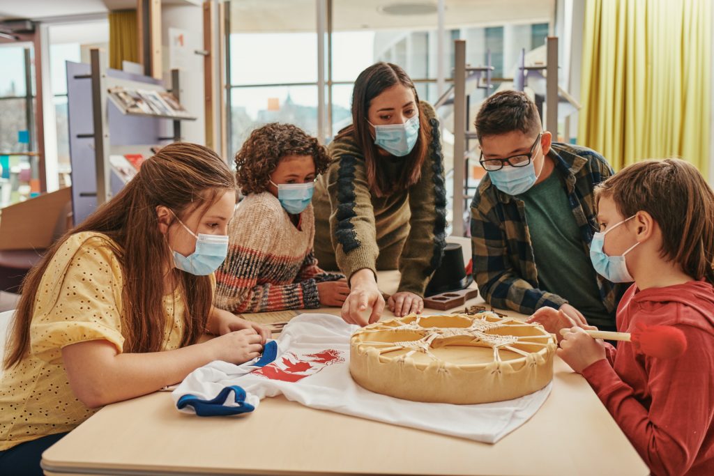 Students looking at artifacts with teacher