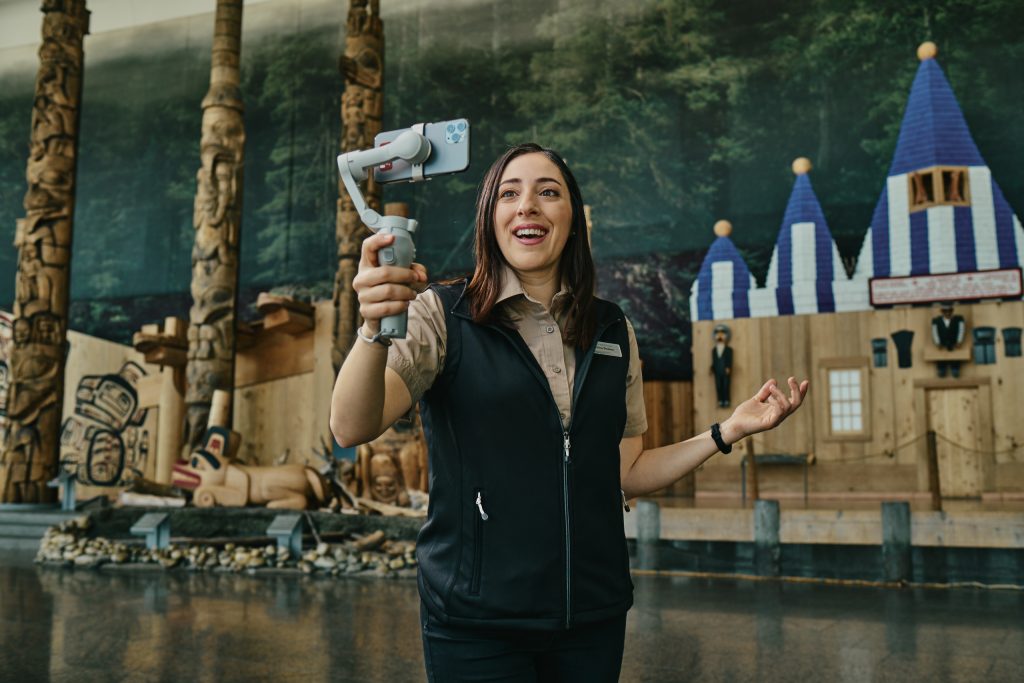 Woman standing in Grand Hall with camera phone