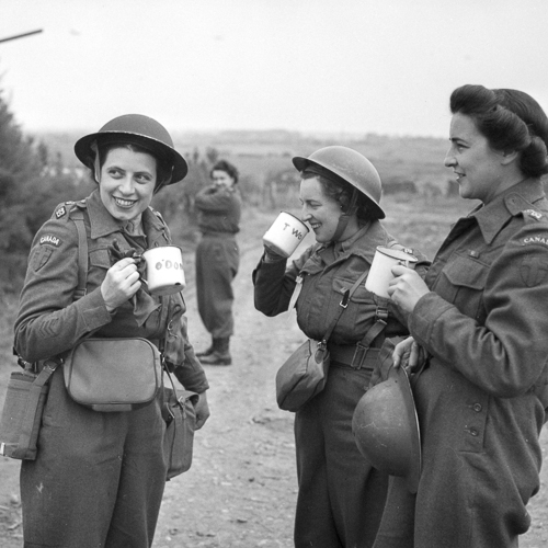 Three women in military uniforms drinking coffee