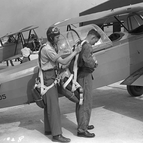 Two men standing next to a biplane in Ottawa.