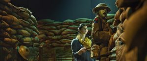 A woman is standing in the Canadian War Museum, surrounded by sacks.