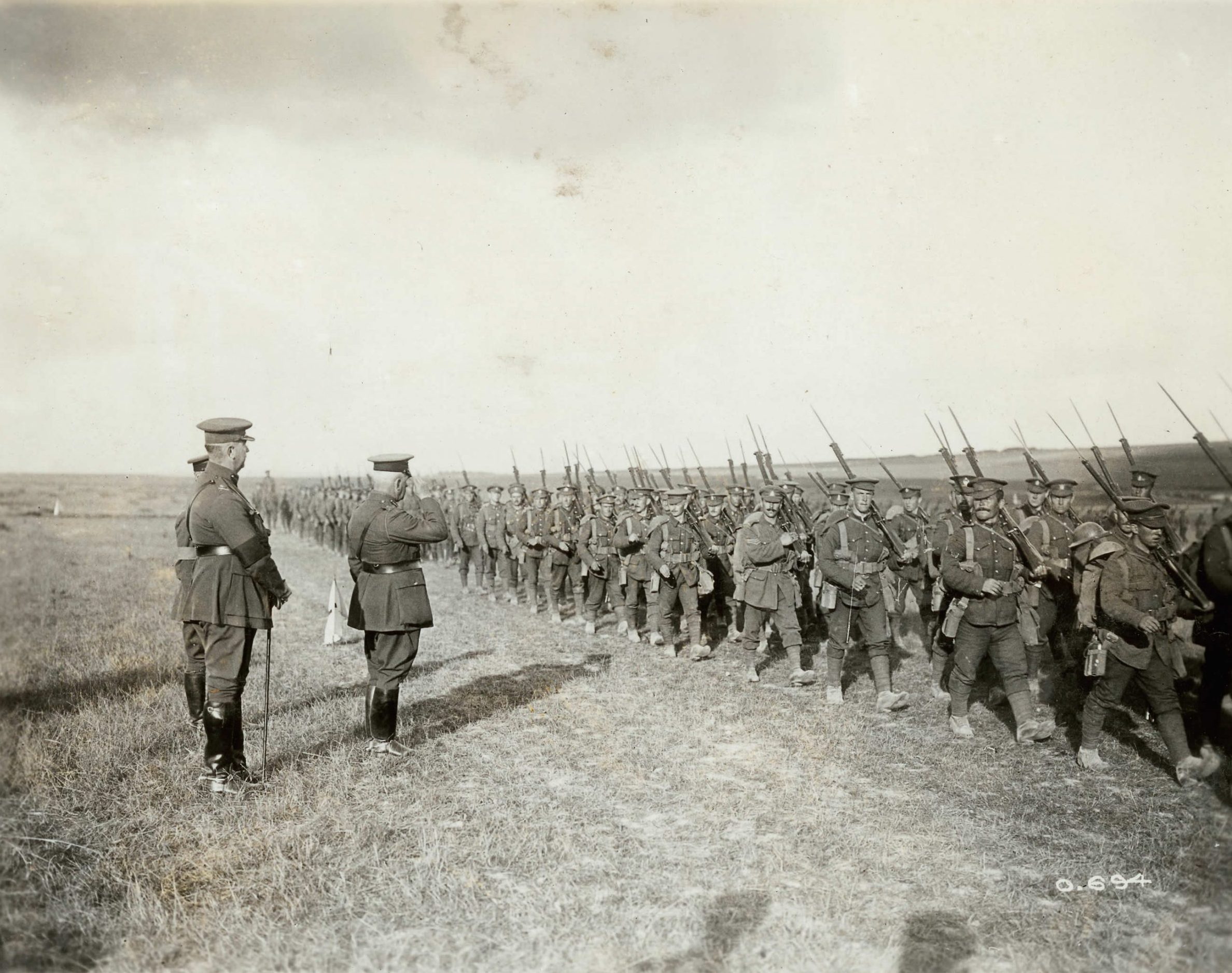 A group of soldiers in uniform marching down a field.