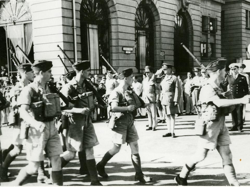 A group of men in uniform from the Canadian War Museum, in Ottawa, walking down a street.