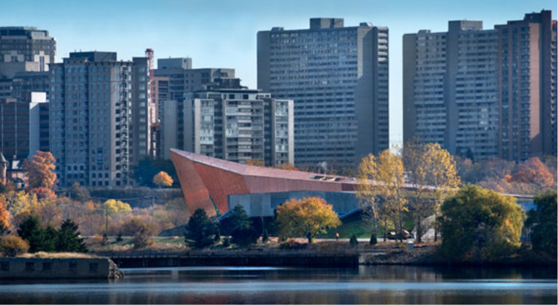 Located in Ottawa, the Canadian War Museum showcases a cityscape adorned with tall buildings and a picturesque river flowing in the background.