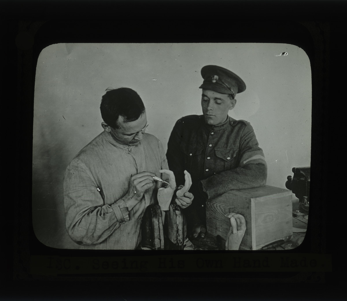 Two men in uniforms working on a machine.