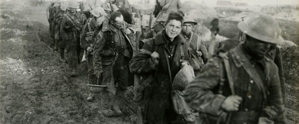 A group of soldiers walking down a dirt road during the First World War.