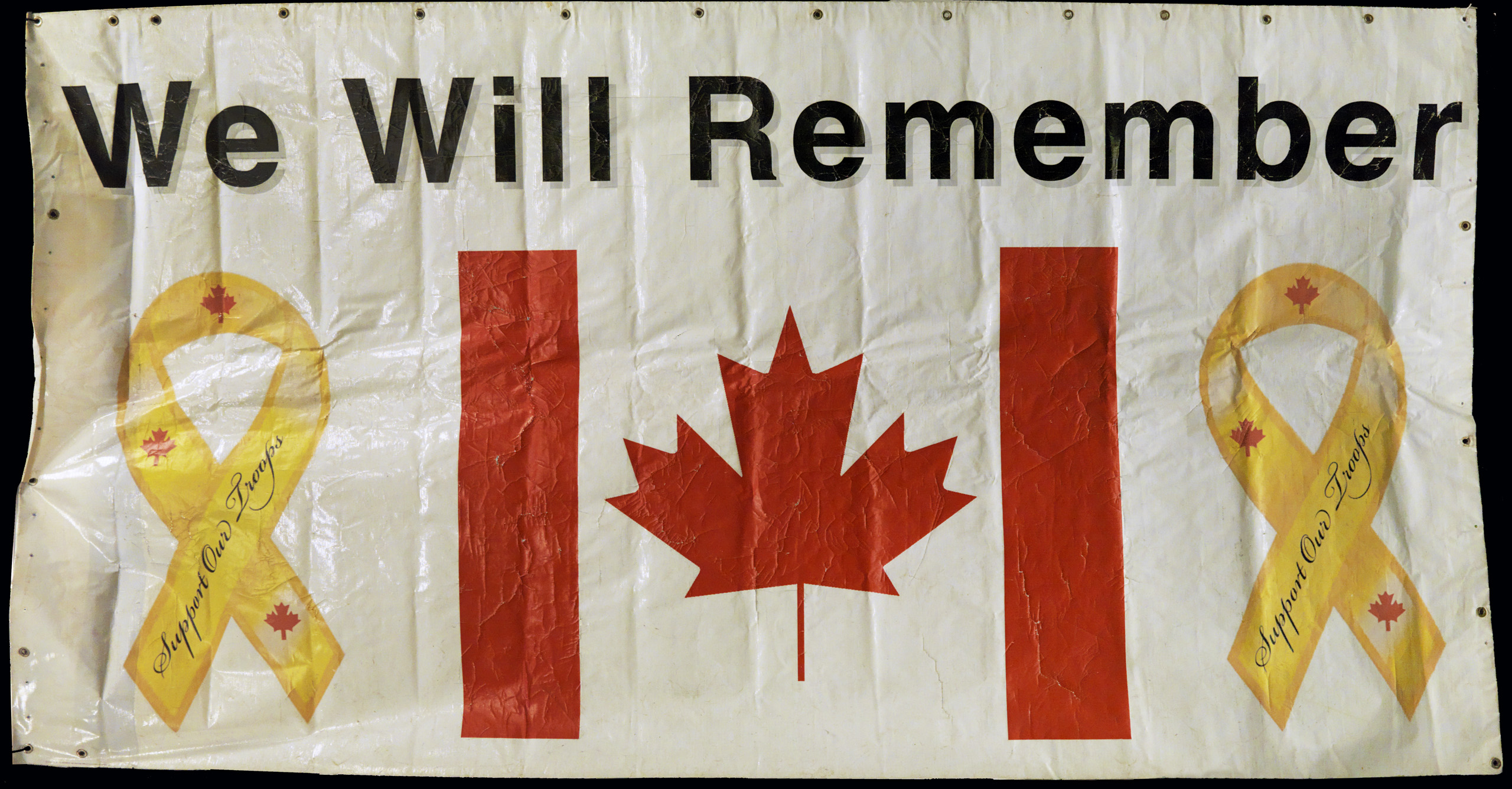 A banner with the words "we will remember" and a Canadian flag in Ottawa at the Canadian War Museum.