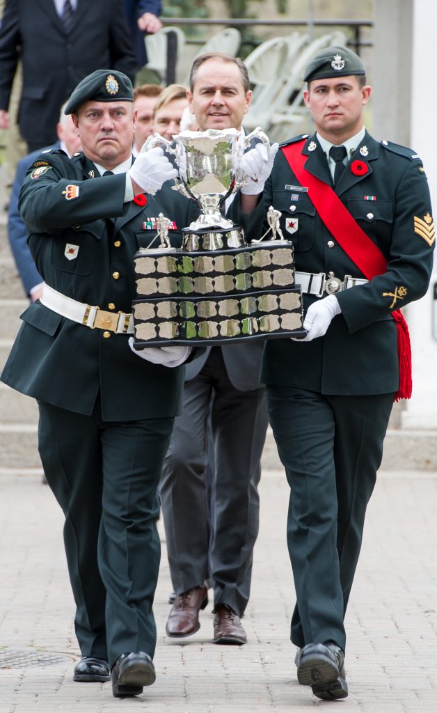 Two men in military uniforms carrying a trophy at the Canadian War Museum in Ottawa.