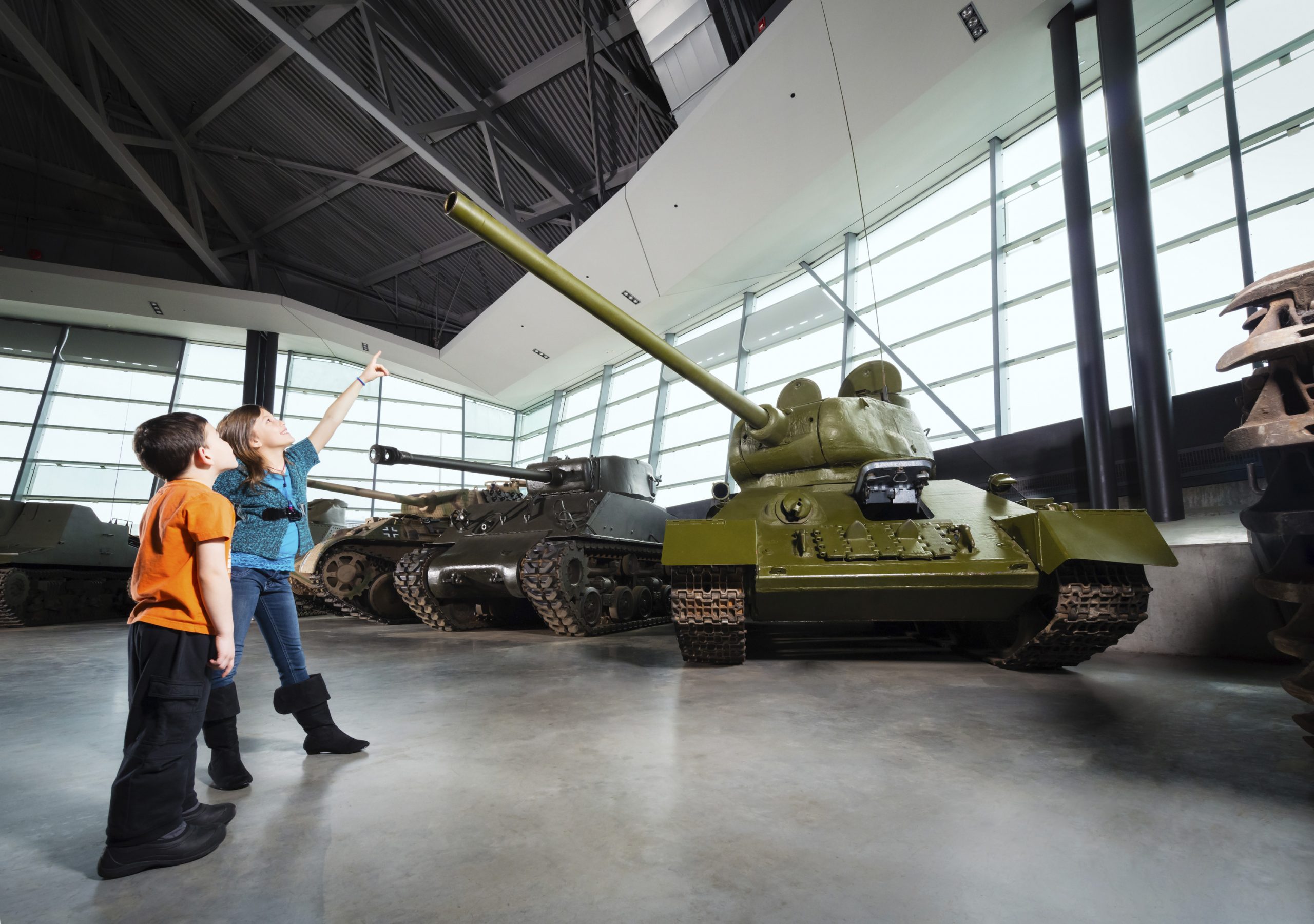 Two children looking at a tank in a museum.