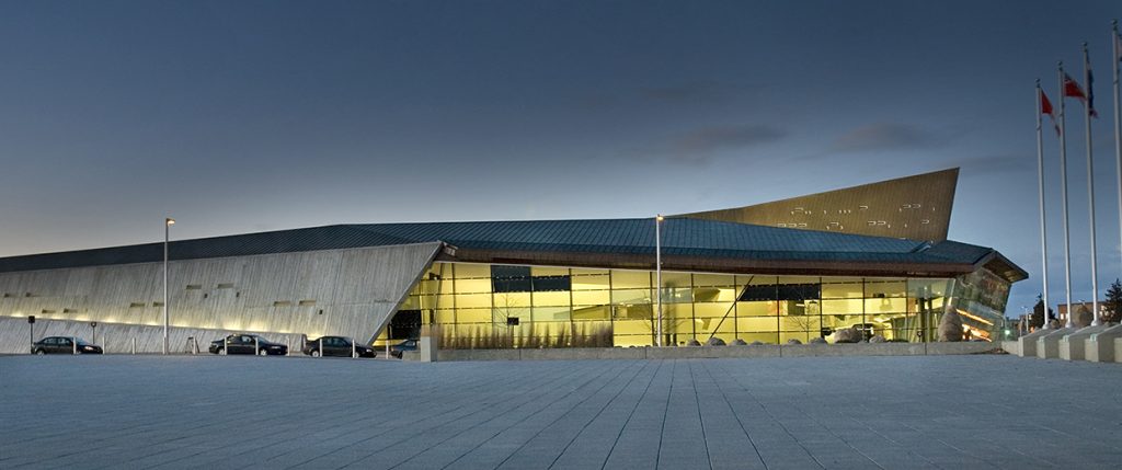 A modern building at night with flags and flags.