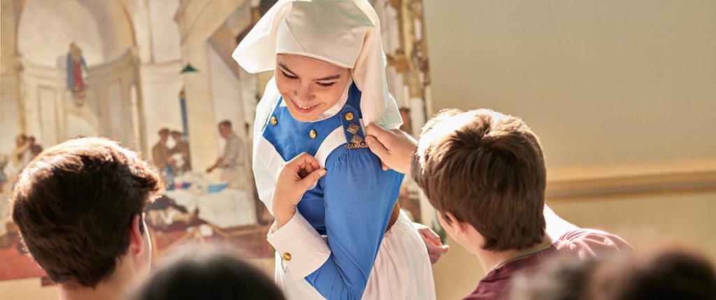 A woman in a blue uniform is helping a group of people.