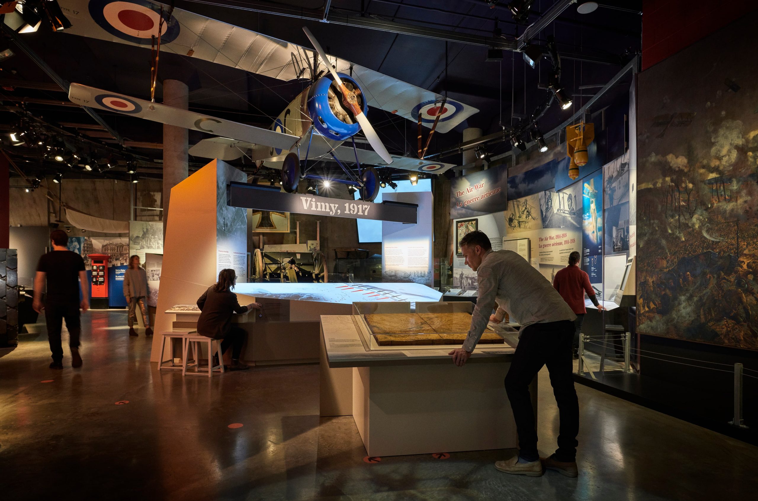 A group of people looking at a display at the Canadian War Museum.