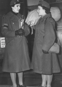 Two women in military uniforms talking to each other.