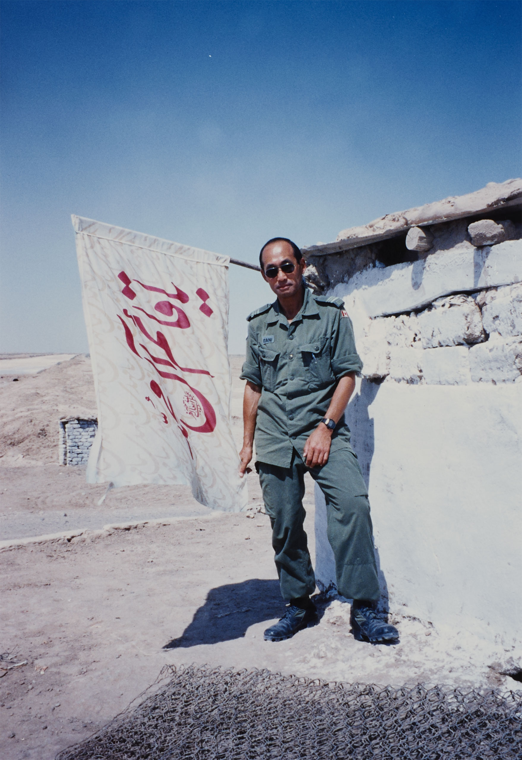 Ted Itani wears a uniform and sunglasses.